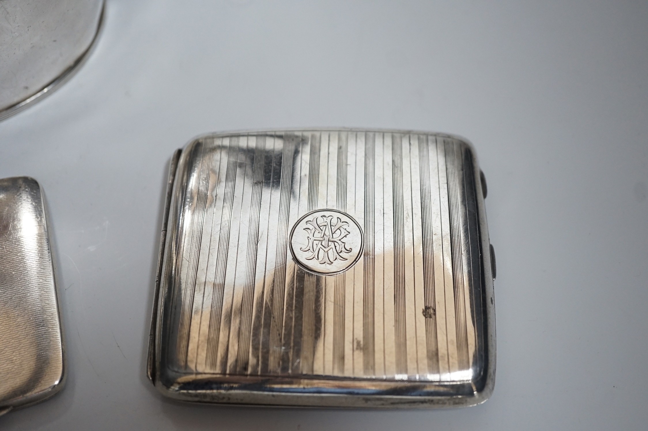 A George V silver oval teapot, Birmingham, 1913, three silver cigarette cases and a silver matchbox holder, gross weight 29oz.